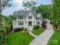 Immaculate two-story home boasts lush landscaping, charming curb appeal, and a private driveway leading to detached garage at 331 Anthony Cir, Charlotte, NC 28211
