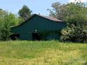 A rustic green barn surrounded by lush green grass and trees at 4194 Buffalo Shoals Rd, Maiden, NC 28650