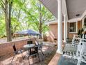 Covered patio with outdoor dining set, brick accent wall, and view of the yard, ideal for relaxation at 500 Colony Acres Dr, Charlotte, NC 28217