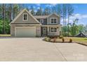 Lovely two-story home boasts stone accents, a two-car garage, and manicured landscaping at 539 Morrison Farm Rd, Troutman, NC 28166