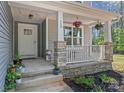 Charming front porch with stone accents, hanging plants, and a cozy seating area at 539 Morrison Farm Rd, Troutman, NC 28166