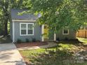 Inviting exterior view of a gray home, showcasing a walkway and a bright yellow front door at 704 Guinn St, Clover, SC 29710