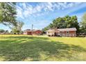 Large, grassy backyard featuring an outdoor seating area, complemented by a detached garage at 704 Kingman Dr, Charlotte, NC 28217