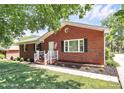 Quaint brick home with a well-kept lawn, a small garden and an American flag on display at 704 Kingman Dr, Charlotte, NC 28217