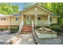 Charming single-story home featuring a welcoming front porch with brick steps, a well-maintained lawn, and mature trees at 7888 Golf Course N Dr, Denver, NC 28037