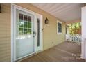 View of the front porch that includes the front door, light fixture, and wooden porch at 7888 Golf Course N Dr, Denver, NC 28037