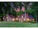 Charming home exterior featuring a lush lawn, mature trees, and a welcoming front facade at 8400 Prince Valiant Dr, Waxhaw, NC 28173