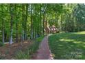 A brick path leads to this house through a wooded area at 8400 Prince Valiant Dr, Waxhaw, NC 28173