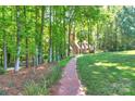 Beautiful home set back from the street, showcasing a brick path and serene greenery at 8400 Prince Valiant Dr, Waxhaw, NC 28173