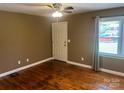 Bright bedroom featuring hardwood floors, a ceiling fan, and a window with backyard views at 907 Mcgowan Rd, Shelby, NC 28150