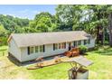 Aerial view of the home highlighting its light gray siding, brown roof, wooden porch and mature trees surrounding the property at 10230 Hagers Rd, Huntersville, NC 28078
