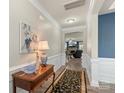 Hallway with a decorative table lamp, leading to the living area with a fireplace and a wall-mounted television at 108 Wrangler Dr, Mooresville, NC 28115