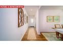 Inviting hallway with hardwood floors, decorative wall art, and a view of the front door at 11128 Cardinal Creek Ave, Charlotte, NC 28215