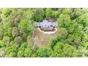 Estate home with a well-manicured lawn, a spacious deck, beautiful landscaping, and surrounded by dense, mature trees at 115 Forestcliff Ne Ct, Concord, NC 28025