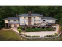 Expansive home exterior with brick accents, a multi-level deck, mature landscaping, and patio seating perfect for outdoor entertaining at 115 Forestcliff Ne Ct, Concord, NC 28025