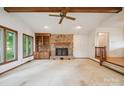 Bright living room features a ceiling fan, large windows, and stone fireplace and built-in shelves at 1205 Southwood Dr, Newton, NC 28658