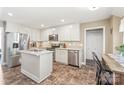Well-lit kitchen with white cabinets, stainless steel appliances, central island, and dark tile flooring, perfect for cooking at 1542 Crowders Woods Dr, Gastonia, NC 28052