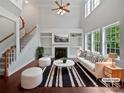 Bright living room with fireplace, built-in shelving, and large windows at 15923 Prescott Hill Ave, Charlotte, NC 28277