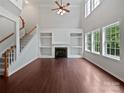 Spacious living room with hardwood floors, fireplace, built-in shelving, and large windows at 15923 Prescott Hill Ave, Charlotte, NC 28277