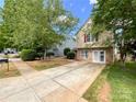 Beautiful two-story home with stone accents, vinyl siding, mature trees, and a long concrete driveway at 2713 Reid Meadows Dr, Charlotte, NC 28208