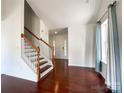 Bright living room featuring hardwood floors, staircase, and large windows with lots of natural light at 2713 Reid Meadows Dr, Charlotte, NC 28208