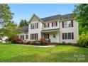 Charming two-story home featuring red shutters and a beautifully landscaped front yard at 305 Phillip Dr, Salisbury, NC 28146