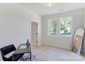 Bright bedroom with two windows, light wood floors, and an adjacent doorway at 3300 Travis Nw Ln, Concord, NC 28027