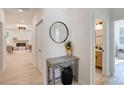 Inviting hallway with decorative table, round mirror, and view into the living room and bathroom at 3300 Travis Nw Ln, Concord, NC 28027