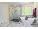Bright bathroom with a luxurious soaking tub, separate glass shower, and elegant marble tile at 424 Preston Rd, Mooresville, NC 28117