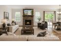 Bright living room featuring a stone fireplace and a seamless transition to the outdoor deck at 424 Preston Rd, Mooresville, NC 28117