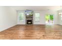 Open-concept living area boasts gleaming wood floors and a stone fireplace at 424 Preston Rd, Mooresville, NC 28117