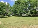 Expansive backyard featuring a lush green lawn, mature trees, and potential for outdoor activities at 4630 Roberta Rd, Concord, NC 28027