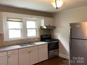 Functional kitchen featuring white cabinets, stainless steel appliances, and a double sink under a window at 4630 Roberta Rd, Concord, NC 28027
