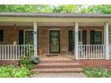 Inviting front porch featuring brick steps, white columns, and space for seating, perfect for relaxing outdoors at 480 S Ingleside Farm Rd, Iron Station, NC 28080