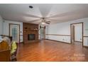Bright living room featuring hardwood floors, a brick fireplace, and neutral walls, ready for personalization at 480 S Ingleside Farm Rd, Iron Station, NC 28080