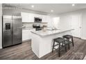 Modern kitchen with white cabinets, granite countertops, stainless steel appliances, and a breakfast bar at 5216 Mccallum Meadows Dr, Charlotte, NC 28216