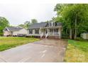 Inviting single-story home with a cozy front porch, long driveway, and lush green lawn at 522 Kittiewake Ln, Clover, SC 29710
