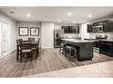 Modern kitchen features stainless steel appliances, dark cabinets, and a granite-topped island with seating at 5220 Mccallum Meadows Dr, Charlotte, NC 28216