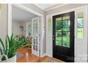 Welcoming foyer with hardwood floors, black front door with glass panes, and adjacent living area visible through glass doors at 530 Bonita Dr, Landis, NC 28088