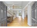 Bright foyer with hardwood floors, a staircase with white railing and a view into the living space at 5940 Four Wood Dr, Matthews, NC 28104