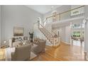 Bright and airy living room features hardwood floors, staircase, and neutral decor at 5940 Four Wood Dr, Matthews, NC 28104