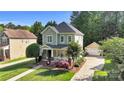 Charming two-story home with a welcoming front porch, flower garden and a detached garage at 7814 Knox Ridge Rd, Huntersville, NC 28078