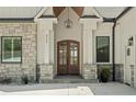 Elegant entrance featuring a stone facade, modern lighting, and a stylish wood door at 8044 Edgewater Dr # 100, Norwood, NC 28128