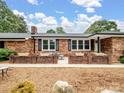 Relaxing front porch with brick features and cozy outdoor seating area at 895 Furnace Rd, Iron Station, NC 28080