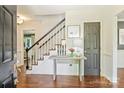 Inviting foyer features hardwood floors, staircase with black railings, and a decorative console table at 9209 Cameron Wood Dr, Charlotte, NC 28210