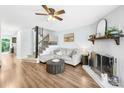 Cozy living room with fireplace, ceiling fan, modern furnishings, and wood flooring at 9214 N Vicksburg Park Ct, Charlotte, NC 28210