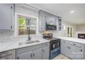 Modern kitchen featuring gray cabinets, stainless steel appliances, and a window overlooking a lush outdoor view at 1141 Carolina Cir, Statesville, NC 28677