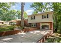 Split level home featuring brick accents, a concrete driveway, and mature trees in a lush, green yard at 118 Spicewood Cir, Troutman, NC 28166