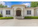 Welcoming home entrance with a stylish portico, double wood doors, and manicured greenery providing instant curb appeal at 1655 Buckland Ct, Indian Land, SC 29707