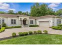 Elegant house with a well-manicured lawn, beautiful landscaping, and a neutral palette, enhancing its luxurious appeal at 1655 Buckland Ct, Indian Land, SC 29707